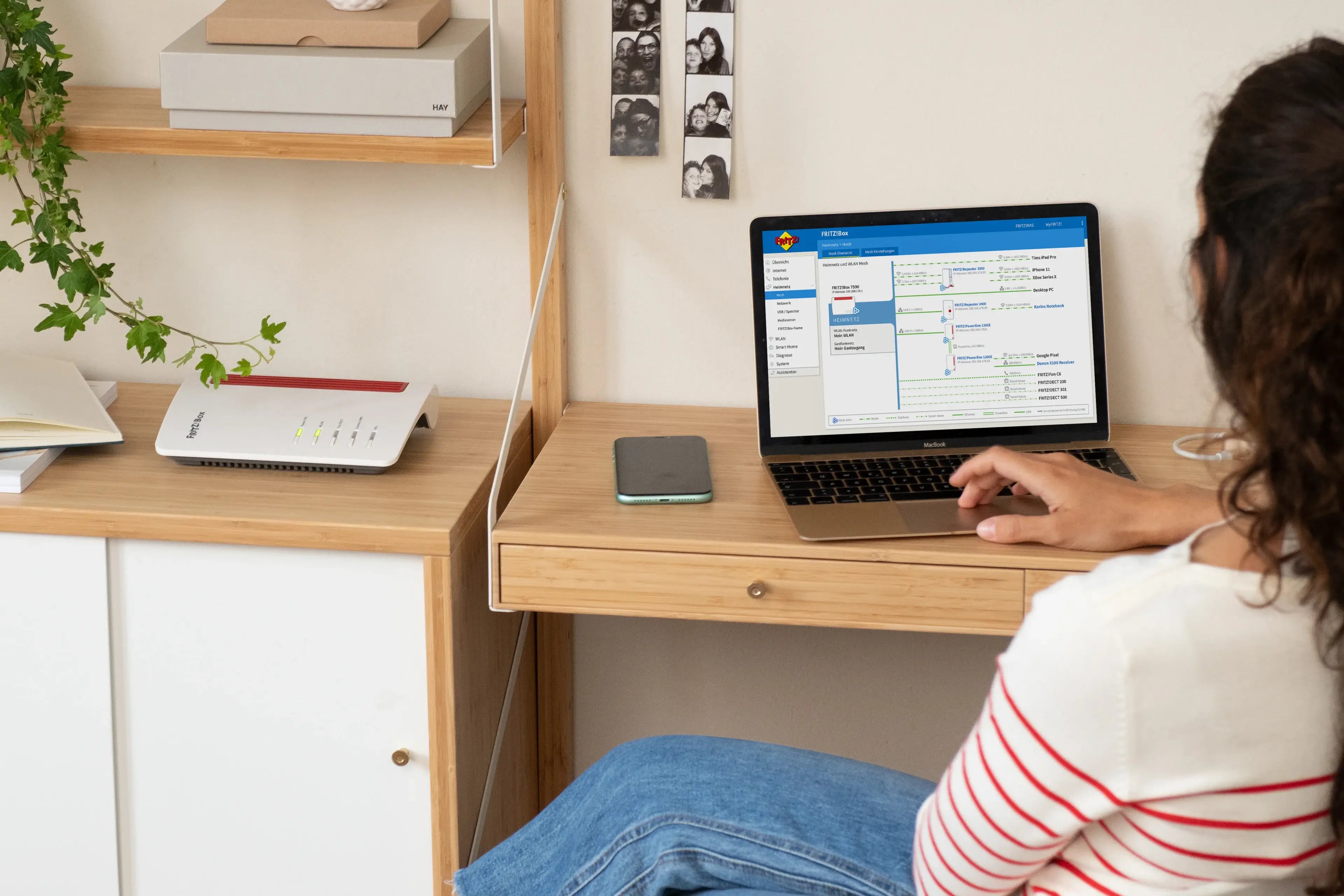 Frau an Laptop mit aufgerufenem Menüpunkt "Mesh" der Benutzeroberfläche der FRITZ!Box.